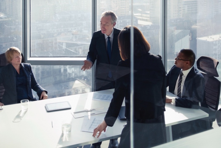 Man presenting to group at conference table